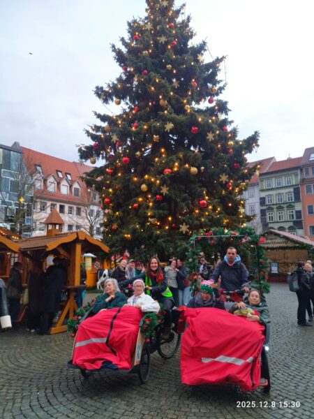 zwei Rikschas auf einem Weihnachtsmarkt vor einem Weihnachtsbaum